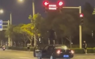 郑州一男子坐车顶开车还闯红灯 分享视频被网友举报：官方称危险驾驶将处罚