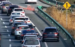 高速堵车 女子开奥迪Q5在交警眼皮底下走应急车道：罚200、扣6分